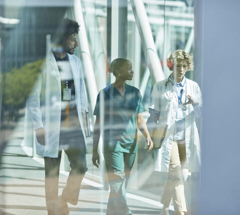A photo of three doctors walking in a hospital