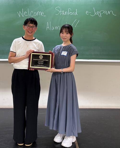 Two women holding a plaque