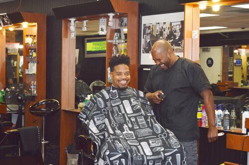 A barber and patron at one of the barbershops in Oakland where men were recruited for the clinical trial about diversity in health care. Photo: Nicole Feldman