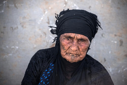 MOSUL, IRAQ - An elderly woman with tribal tattoos on her face rests in Khazir refugee camp on April 15, 2017 near Mosul, Iraq. Khazir camp for displaced persons. mosul old woman