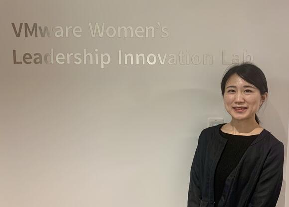 a student posing in front of a sign