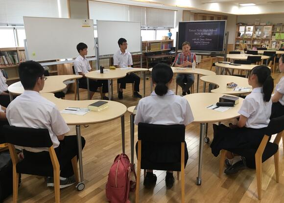 students and an instructor sitting in a circle in a classroom