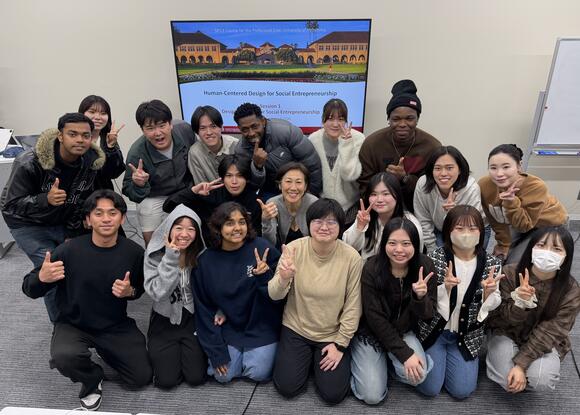 group of students posing in front of a screen
