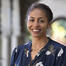 An African American woman wearing a floral blouse and smiling. 