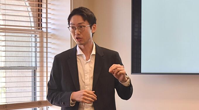 Gidong Kim delivers a presentation in a conference room.
