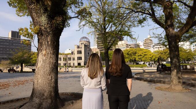 Victoria Kelly and Karin Tanabe stand with their backs to the camera, facing the Hiroshima Peace Memorial, also known as the Atomic Bomb Dome, in Hiroshima, Japan.