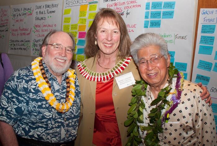 three people with leis smiling
