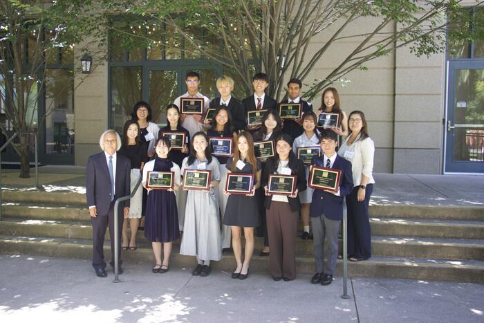 students standing outside with their plaques