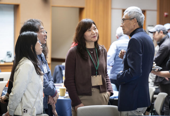 Xiaonian Xu speaks with members of the audience during a break in the conference.