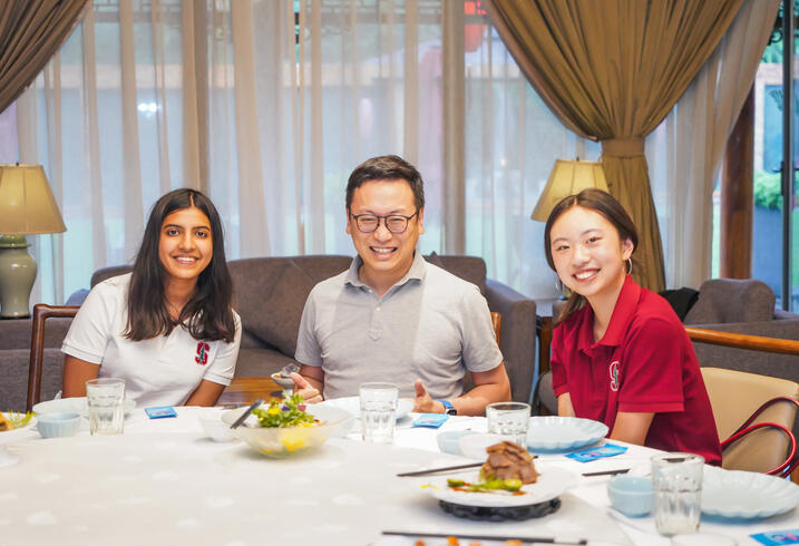 Students pose at a dinner table in China.