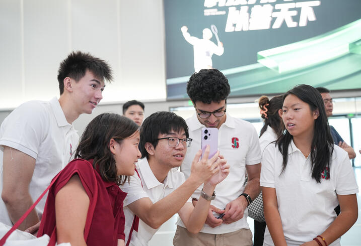 Students look a a phone together.