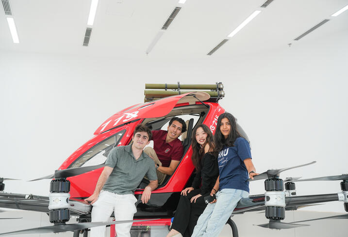 Students pose with a model helicopter.