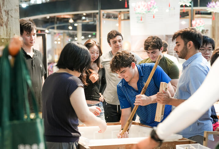 Studnets stir a large pot.