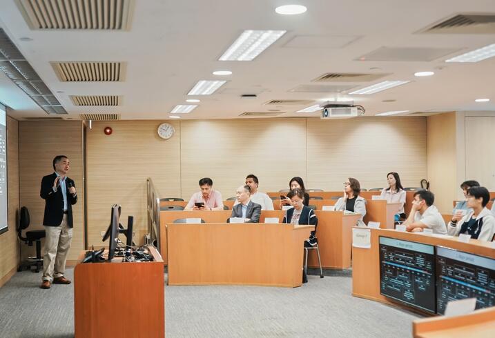 A professor lectures a group of students in a classroom.