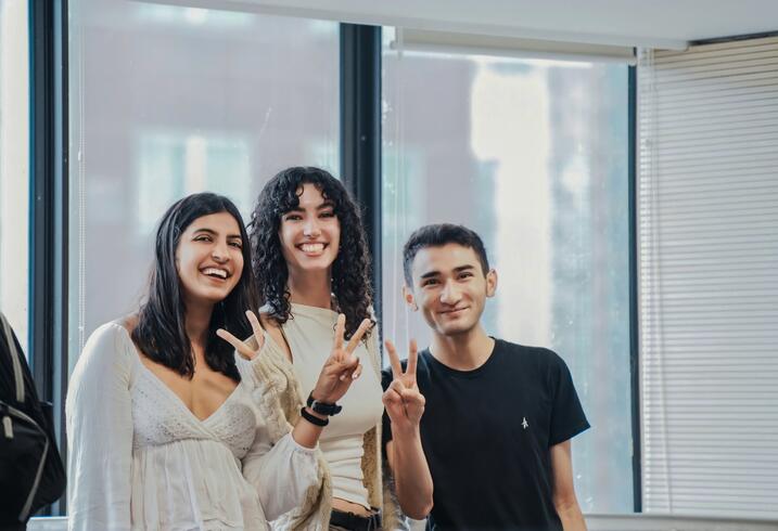 Smiling students with peace signs.