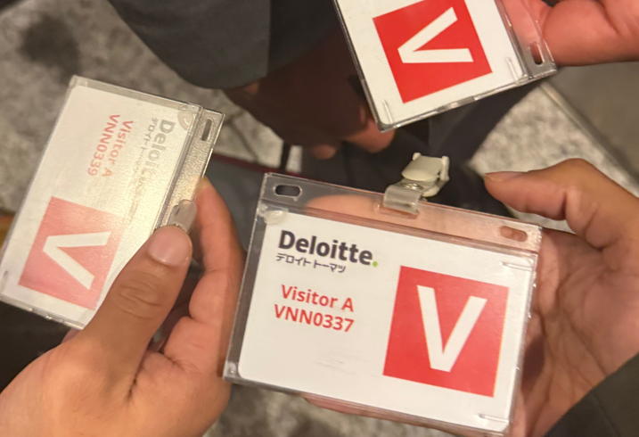 MIP students display their visitor badges to the Deloitte company in Japan.