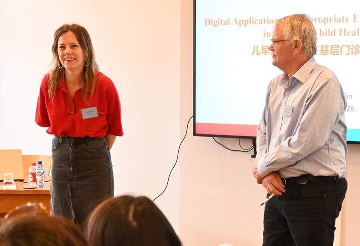 Dorien Emmers and Scott Rozelle deliver remarks at the front of a conference room.