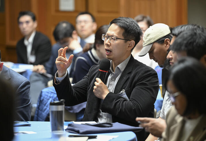 An audience member speaks into a handheld mic.