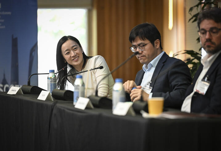 Jen Pan smiles while seated at a table for a panel discussion.
