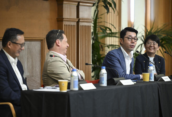 Four people sit behind a table during a panel discussion.