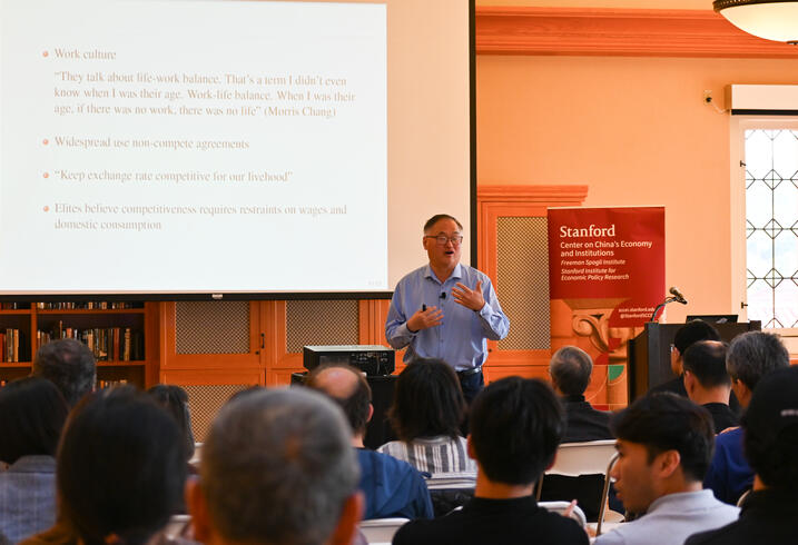 Chang-Tai Hsieh speaks during a lecture in a library. 