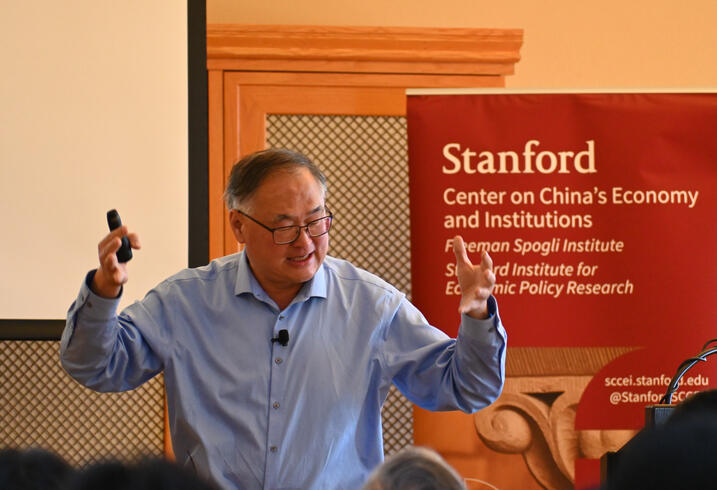 Chang-Tai Hsieh speaks during a lecture in a library. 