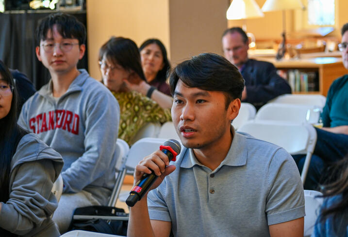An audience member speaks into a handheld mic.