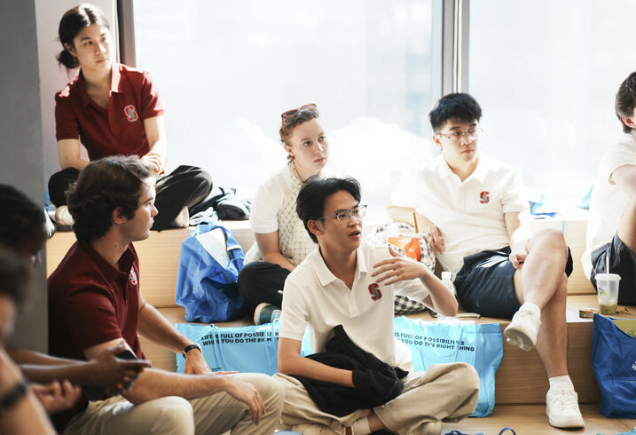 Students sit on steps in conversation. 