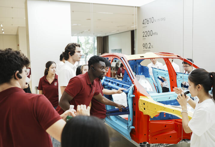 Students look into a model xiaomi car. 
