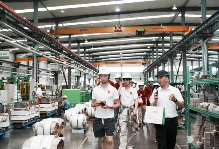 Students walk through the TGOOD factory floor.