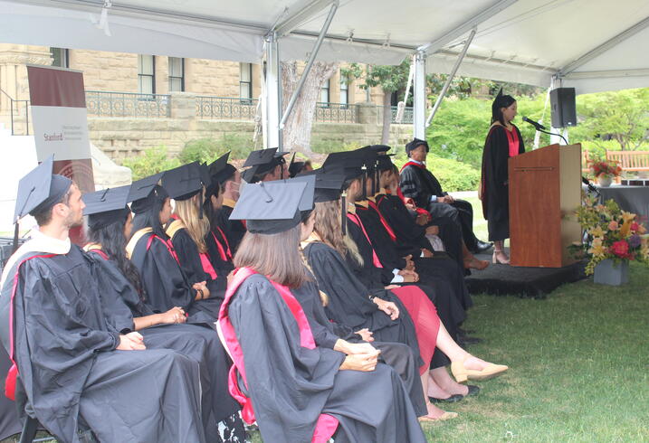 Members of the 2022 graduating class of the Ford Dorsey Master's in International Policy listen to graduation remarks outside of Encina Hall on June 12, 2022.