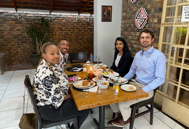 Janani Mohan and Eli MacKinnon share a meal with their UNDP partners in South Africa.