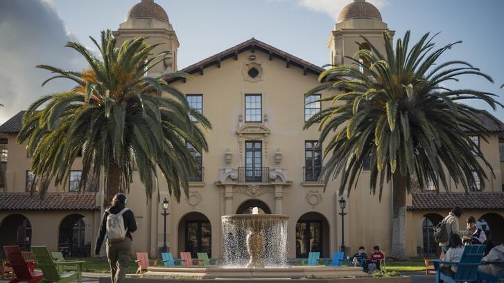 a fountain and two palm trees in front of a building