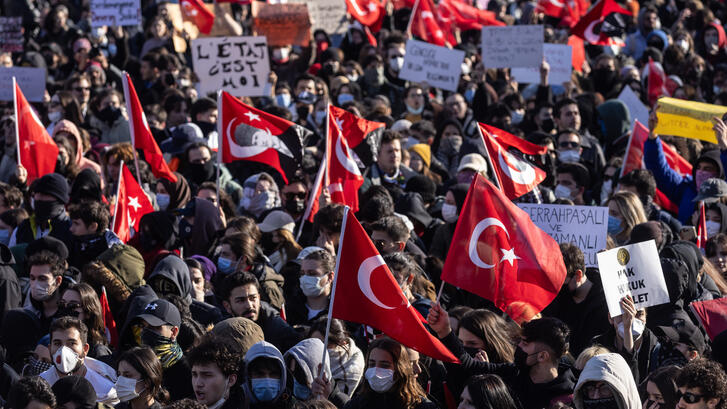 Protesters chant slogans during a protest march holding Turkish flags