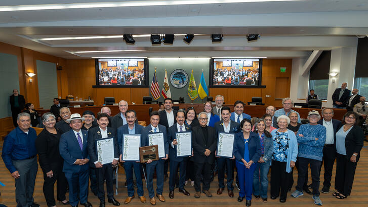 people and suits and dresses standing in a room
