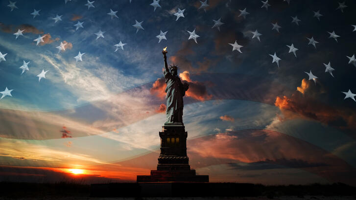 Sunset with overlaid American flag and Statue of Liberty