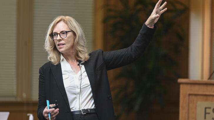 Kathryn Stoner gestures toward the screen during a lecture in Encina Hall