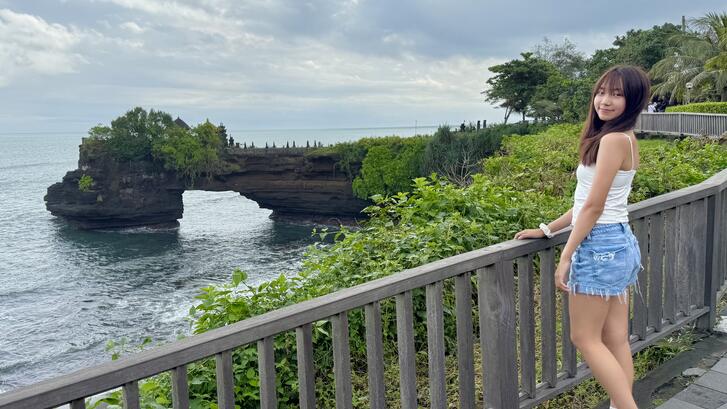 a person standing in front of Tanah Lot