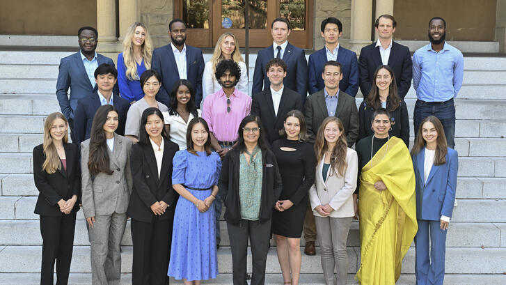 The class of 2027 of MIP students standing on the steps in front of Encina Hall at Stanford University.
