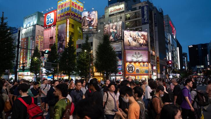 People cross a road in the Akihabara district in Tokyo, Japan.