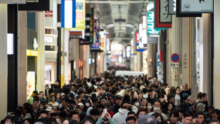 People walk through a shopping street in Osaka, Japan, 2024.