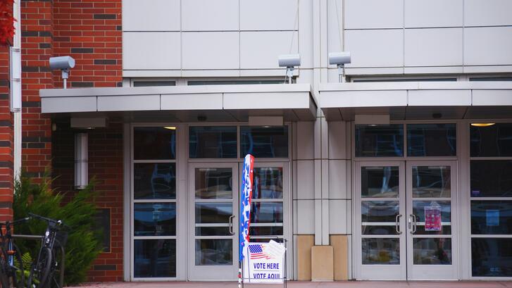 Building with glass doors and polling station signage out front