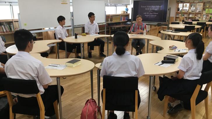 students and an instructor sitting in a circle in a classroom