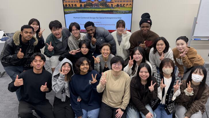 group of students posing in front of a screen