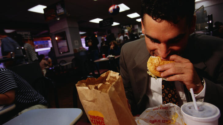 A man eating a hamburger at Burger King