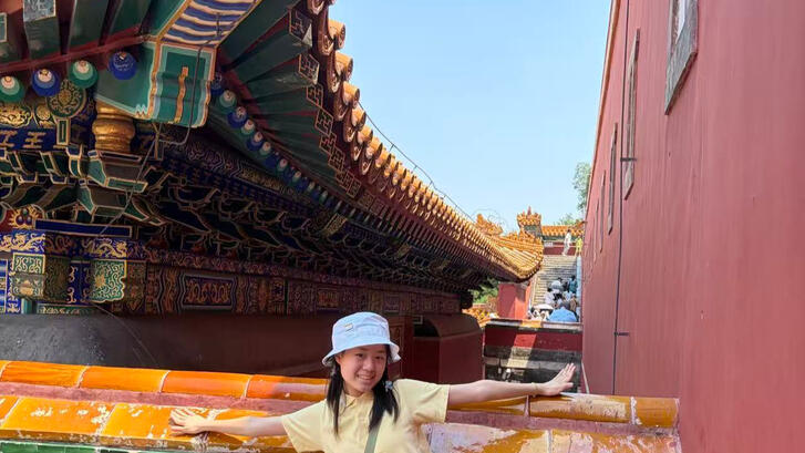 a student standing in front of a building
