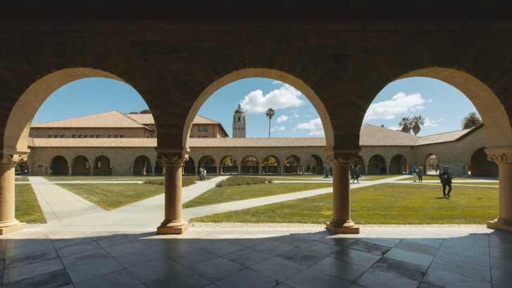 A view of the Stanford memorial quad with arches in the forefront. 