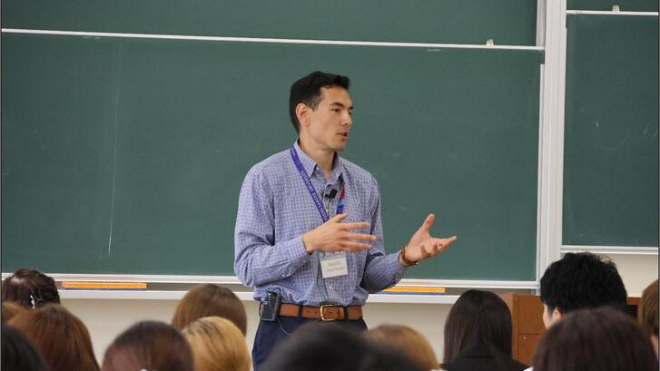 a person giving a talk in front of a class