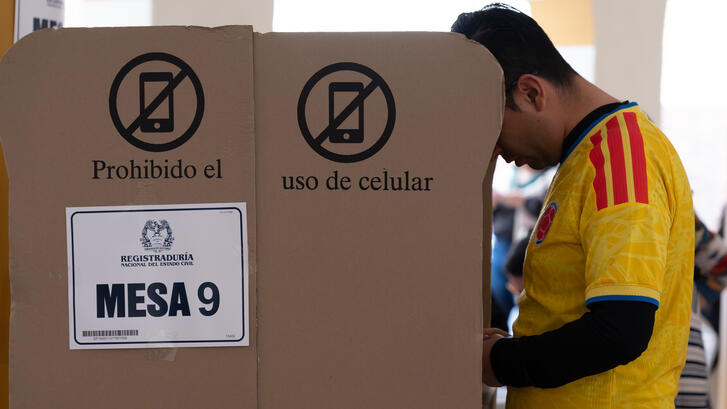 A man in a Colombian football jersey casts his vote in the presidential election on May 31, 2026, in Bogotá, Colombia.