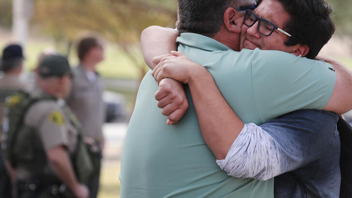 A boy hugs his father after a school shooting in Santa Clarita, CA.